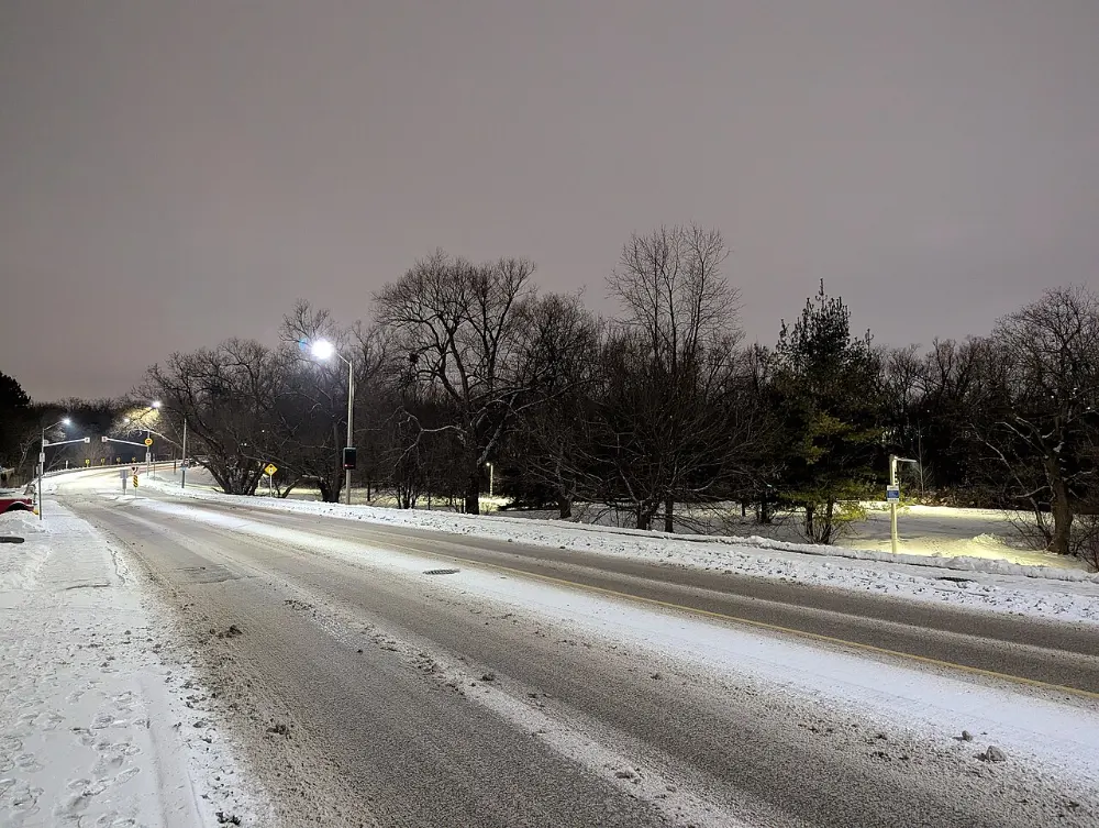 Clarence Street in Brampton at night after a snowfall, with snow on the boulevards and a cleared road